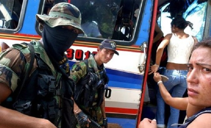 Members of the right-wing paramilitary group the United Self-Defense Forces of Colombia inspect a bus.