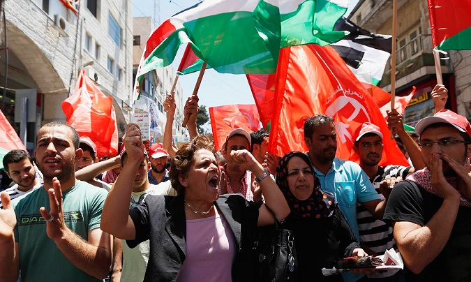 Palestinians wave Palestinian and Popular Front for the Liberation of Palestine (PFLP) flags.