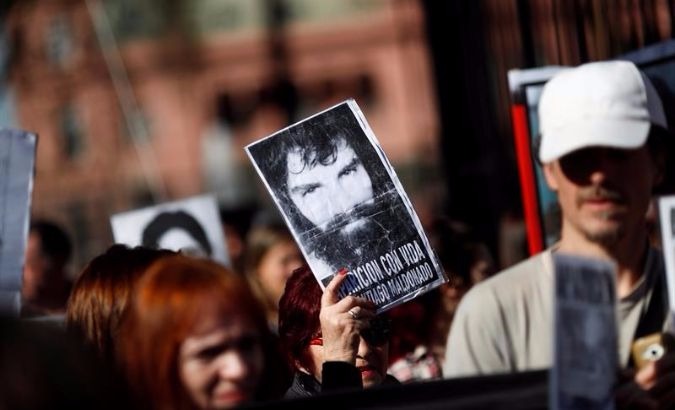 Demonstrators hold up an image of Santiago Maldonado.