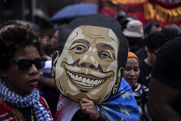An activist holds a mask of Philippine President Rodrigo Duterte outside the Malacanang palace in Manila, Sept. 21, 2017.