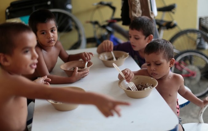 Honduran children eat at the Todo por Ellos shelter in Tapachula.