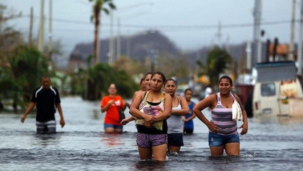 People wade through a flooded street in San Juan after Hurricane Maria.