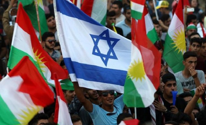 Iraqi Kurds fly an Israeli flag and Kurdish flags during an event to urge people to vote in the upcoming independence referendum.