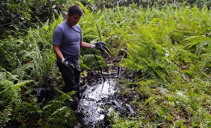 A member of an Indigenous community in Ecuador shows the contamination by Chevron in the Amazon.