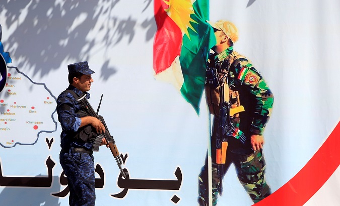 An Iraqi policeman stands next to a banner supporting the referendum for independence of Kurdistan in Erbil, Iraq.