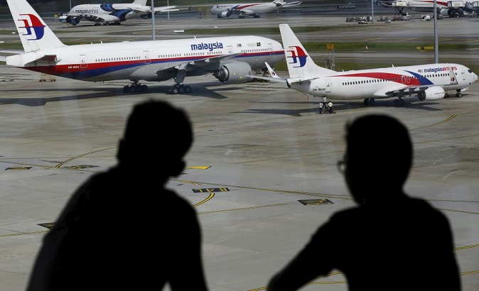Men watch Malaysia Airlines aircraft at Kuala Lumpur International Airport in Sepang, Malaysia.