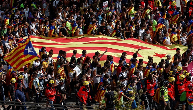 Demonstrators in Barcelona carry a giant Catalan flag.