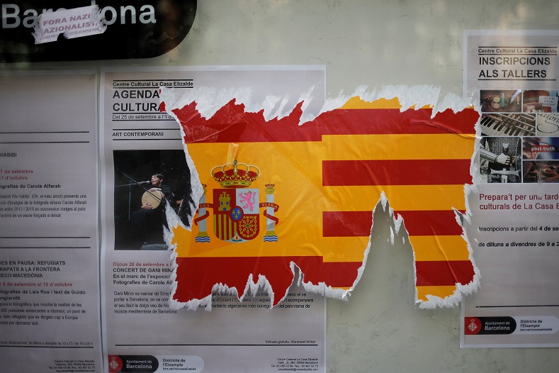 A damaged sticker of the Spanish flag is seen on a wall ahead of the referendum in Barcelona.