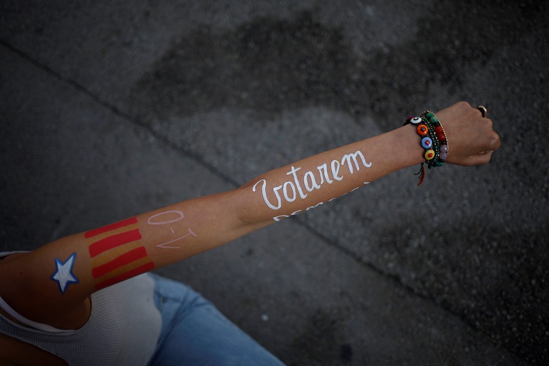 A students shows her arm painted with the colors of an Estelada and the words 