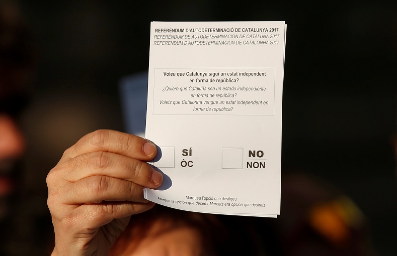 A protester holds a ballot paper with the proposed question for a referendum on breaking away from Spain.