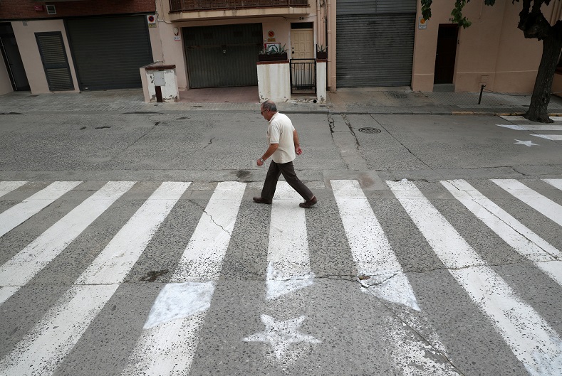 A man walks past a crosswalk, painted in the form of an Estelada in Arenys de Munt, north of Barcelona.