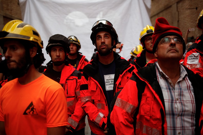 Firemen listen a speech as they attend a gathering at Catalonia's History Museum in Barcelona.