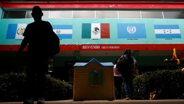 A man walks past pictures of Mexico's and other Central America countries' flags at Belen migrant shelter in Tapachula, Chiapas, Mexico November 16, 2016.
