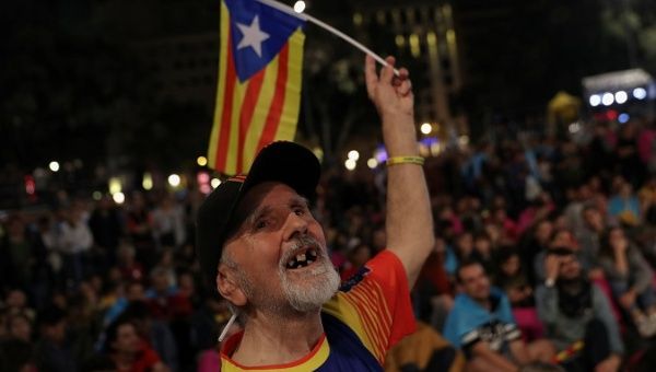 A man waves an Estelada as people gather at Plaza Catalunya after voting ended for the banned independence referendum in Barcelona, Spain, Oct. 1, 2017. 