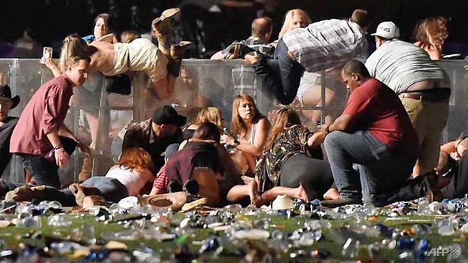 People scramble for shelter at the Route 91 Harvest country music festival after gunfire was heard in Las Vegas, Nevada.