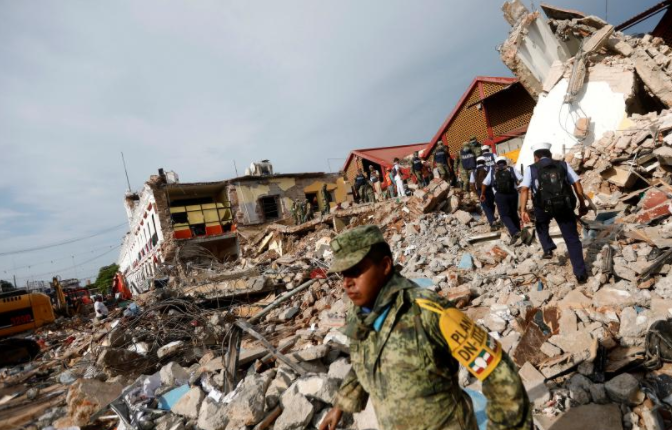 Soldiers work to remove the debris of a house destroyed in an earthquake that struck off the southern coast of Mexico.