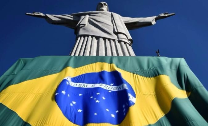 Brazil's flag beneath Christ the Redeemer statue in the city of Rio de Janeiro.