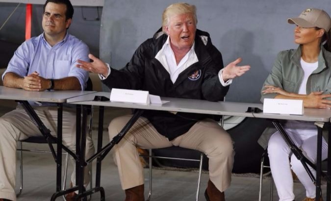 U.S. President Donald Trump sits between Puerto Rico Governor Ricardo Rossello and first lady Melania Trump, San Juan, Puerto Rico.