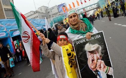 An Iranian woman holds a placard showing a caricature of US President Donald Trump being punched during a rally in Tehran earlier this year.