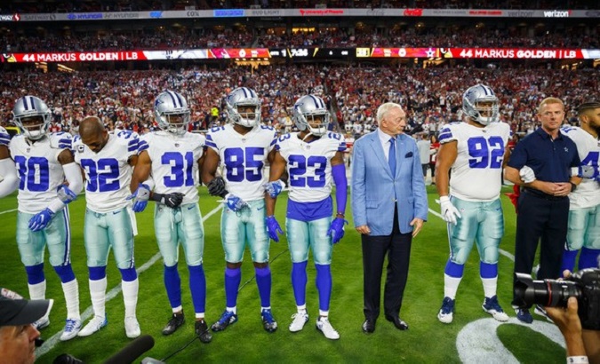 Dallas Cowboy owner Jerry Jones stands with his team before a game against Arizona Cardinals.