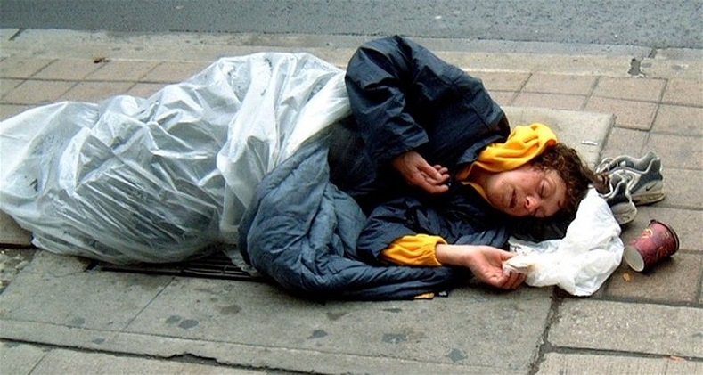 A homeless woman sleeping on a street corner in Bristol, England, United Kingdom.