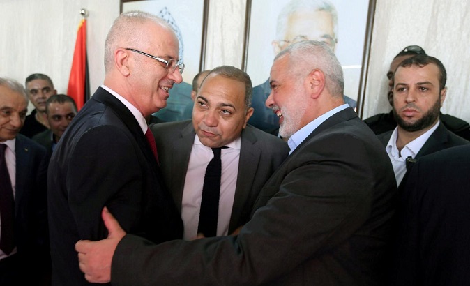 Palestinian Prime Minister Rami Hamdallah (L)  of Fatah shakes hands with Hamas Chief Ismail Haniyeh in Gaza City October 2, 2017.
