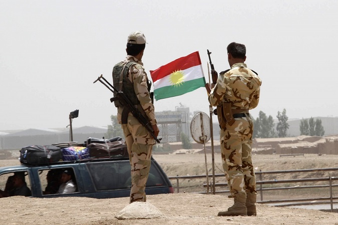 Members of the Kurdish security forces stand at a checkpoint during an intensive security deployment on the outskirts of Kirkuk