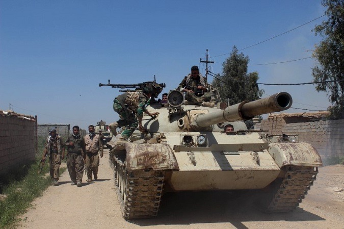 Kurdish Peshmerga forces sit on top of a tank on the outskirts of Kirkuk.