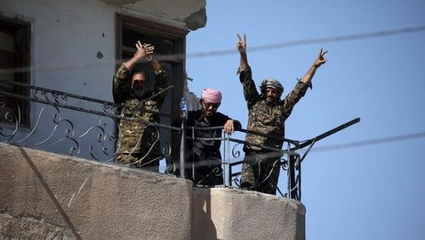 Fighters of Syrian Democratic Forces gesture the 