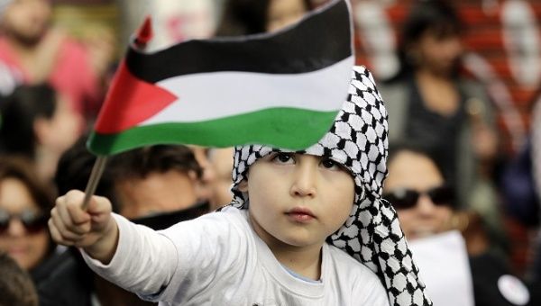 A Palestinian-Chilean child waves a Palestinian flag during a march, Santiago, Chile, August, 2014.