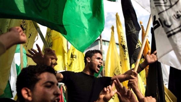 Palestinians wave Fatah and Hamas flags at the square of the Unknown Soldier in central Gaza City. (FILE)