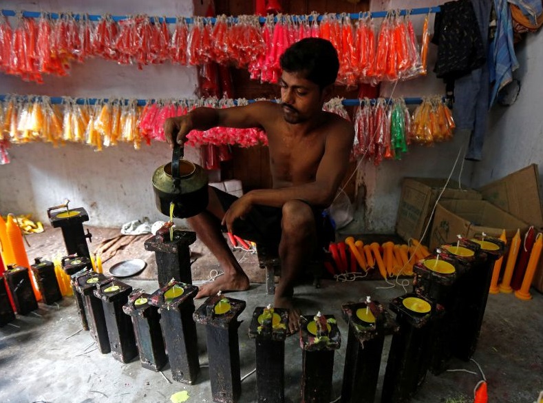 A worker makes candles at a workshop in Kolkata. Candles, too, are used to decorate temples and homes. 