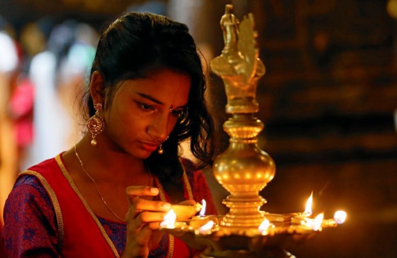 A devotee lights oil lamps at a religious ceremony during the Diwali or Deepavali festival at a Hindu temple in Colombo, Sri Lanka October 18, 2017. 