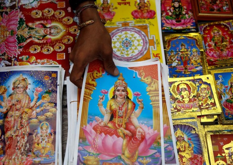 A vendor reach out for the poster of Goddess of Wealth Laxmi, kept on sale for the Tihar festival, also called Diwali, in Kathmandu, Nepal October 15, 2017. 
