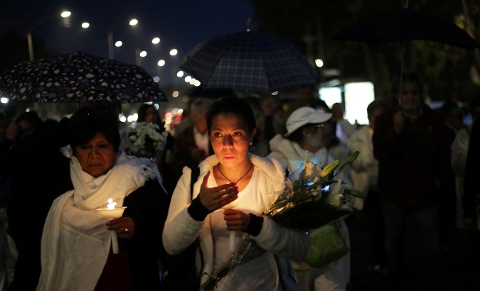 People hold candles as they march along the streets during a homage in memory of the victims who died in the earthquake on September 19, at Miramontes Coapa neighborhood in Mexico City, Mexico.