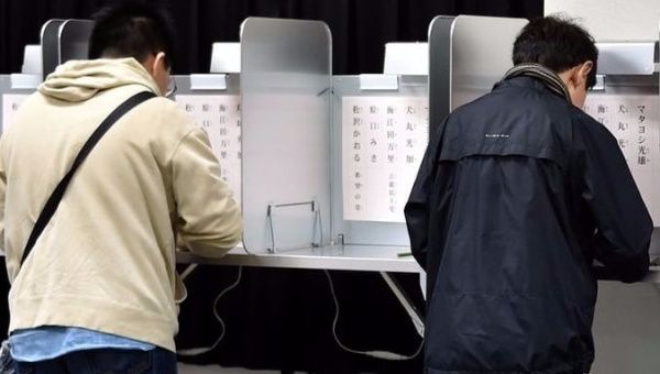 Japanese voters casting their ballots at the polls.