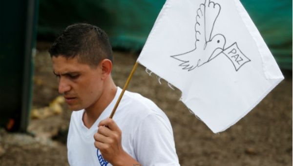 A former FARC member carries a peace symbol.