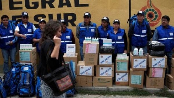 Members of a health brigade look at Bolivia's Health Minister Ariana Campero.