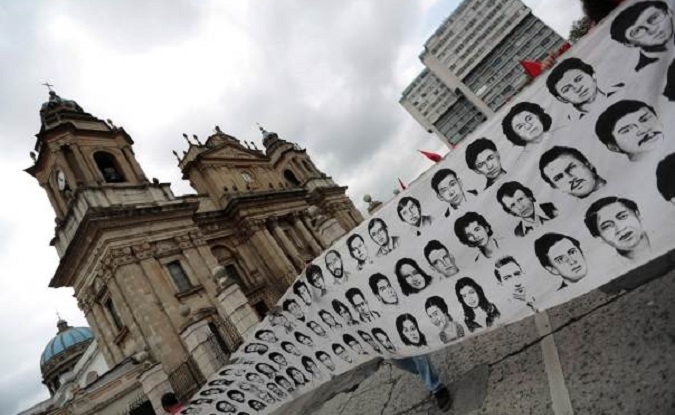Activists hold up a banner with faces of people who disappeared during the 1960-1996 civil war, during a demonstration against the commemoration of the 142nd anniversary of the Guatemalan Army's founding, in Guatemala city June 30, 2013.