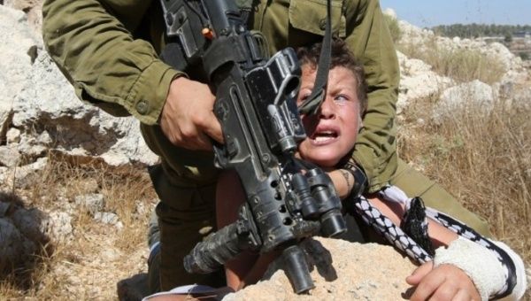 A 2015 photo shows an Israeli soldier attempting to arrest a Palestinian boy. 