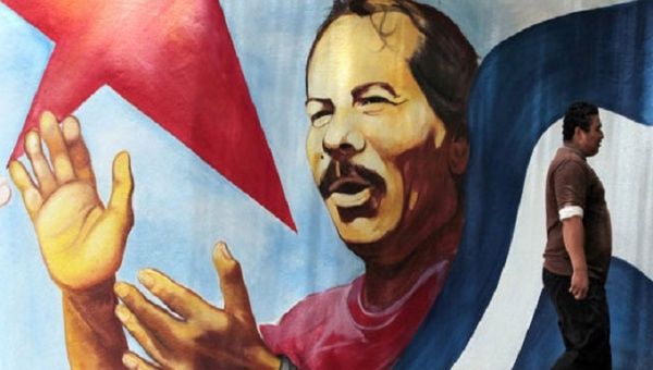 A man walks by a mural of Sandinista President Daniel Ortega.