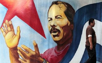 A man walks by a mural of Sandinista President Daniel Ortega.