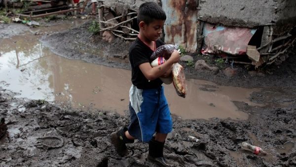 Boy walks in a muddied house in Nicaragua after heavy rains hit the country and neighboring Honduras.