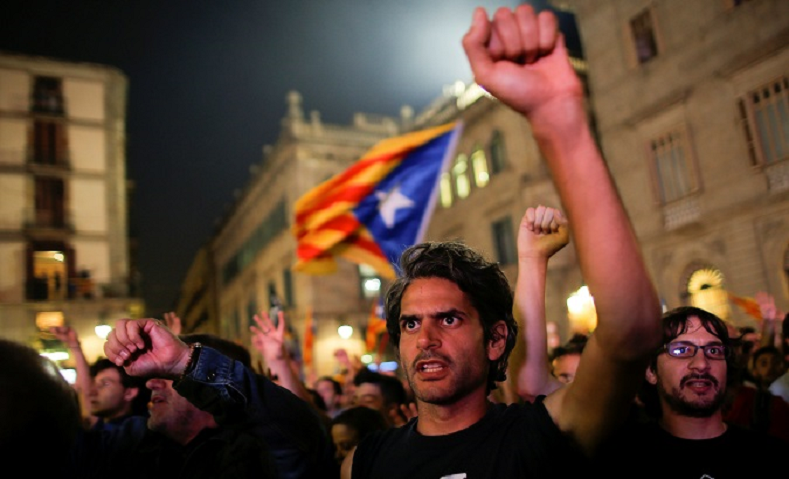 People celebrate in front of the Catalan regional government headquarters after the regional parliament declared independence from Spain in Barcelona.