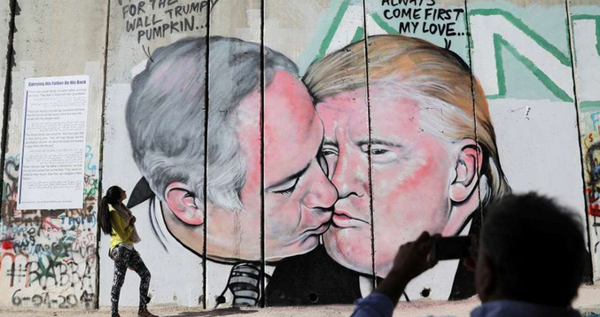 A massive mural of Israeli Prime Minister Benjamin Netanyahu and US President Donald Trump engaged in a passionate kiss was unveiled Sunday morning, October 29, 2017, painted on the West Bank security barrier near the West Bank city of Bethlehem.
