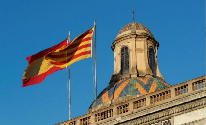 Spanish and Catalan flags flutters atop the Generalitat Palace, the Catalan regional government headquarters in Barcelona, Spain.