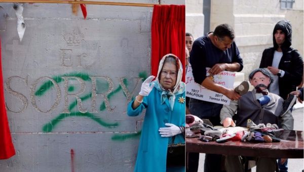 An actress dressed as Britain's Queen Elizabeth II marks the 100th anniversary of the Balfour Declaration, outside Banksy’s Walled Off Hotel in Bethlehem, as Palestinian protesters deface an effigy of the document's author.