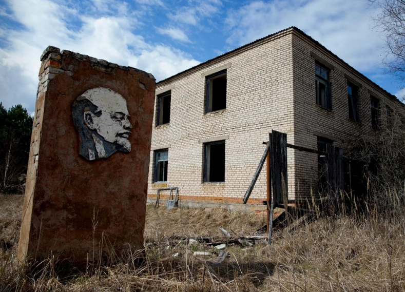 A panel with a portrait of Lenin and an abandoned building are seen at the 30 km exclusion zone around the Chernobyl nuclear reactor in the abandoned village of Orevichi, Belarus.