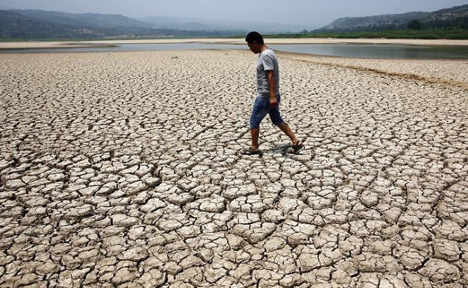 A man walks along the dried-up bed of a reservoir in Sanyuan county, in China's Shaanxi province.