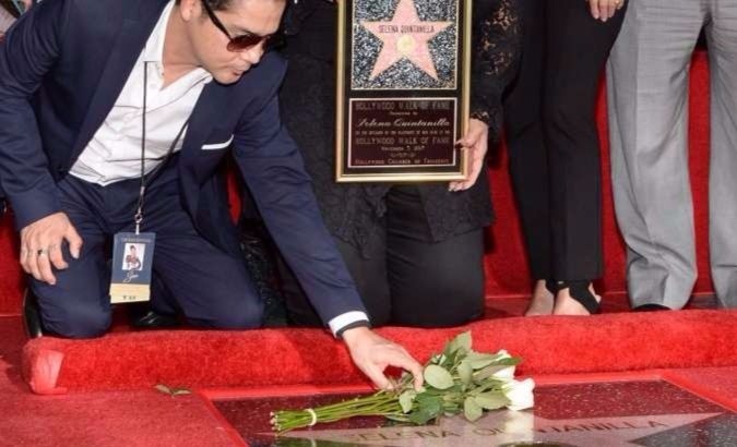 Selena's husband Chris Perez laying flowers on her star.